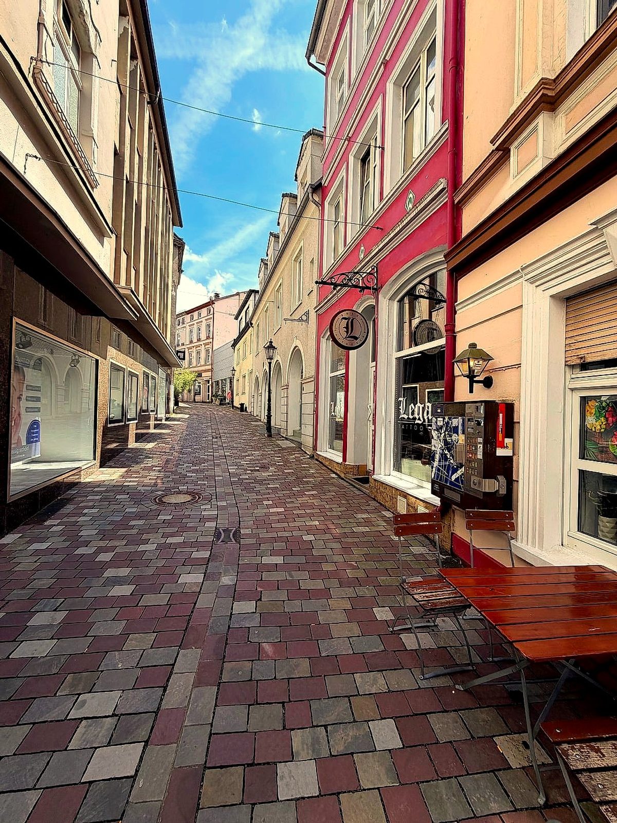 Kopfsteinpflastergasse in der Lüdenscheider Altstadt mit bunten Fassaden und Schaufenstern